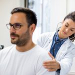 Man is examined by doctor for his workers comp case
